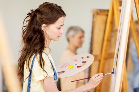 student girl with easel painting at art schoolの写真素材