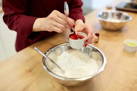 chef hands adding food color into bowl with flourの写真素材