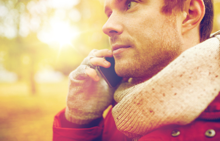 close up of man with smartphone calling in autumnの写真素材