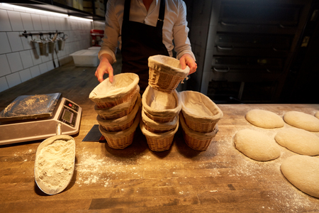 baker with baskets for dough rising at bakery