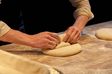 chef or baker cooking dough at bakery