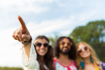 happy hippie woman pointing finger outdoorsの写真素材