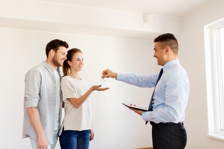 giving keys from new home to happy coupleの写真素材