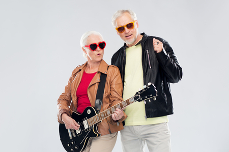 senior couple in sunglasses with electric guitarの写真素材