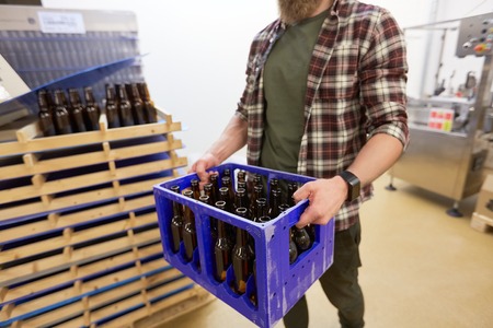 man with bottles in box at craft beer breweryの写真素材