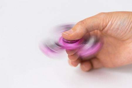 close up of hand playing with fidget spinnerの写真素材