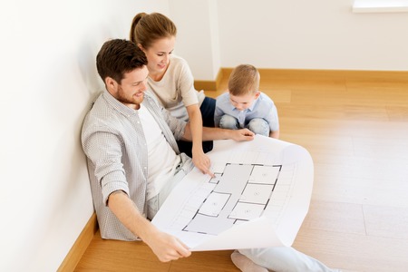happy family with blueprint moving to new home