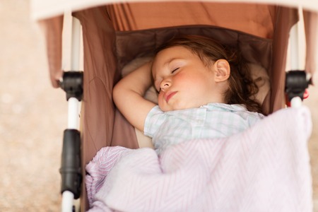 little child or baby sleeping in stroller outdoorsの写真素材