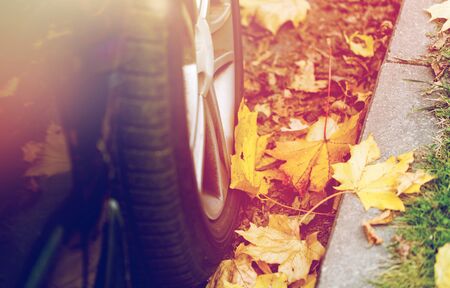 close up of car wheel and autumn leavesの写真素材
