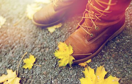 female feet in boots and autumn leavesの写真素材