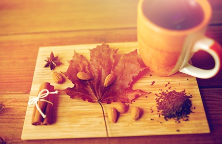 cup of tea, maple leaf and almond on wooden boardの写真素材