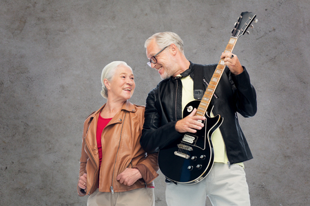 happy senior couple with electric guitarの写真素材
