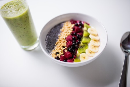 smoothie and bowl of yogurt with fruits and seeds