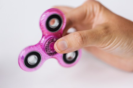 close up of hand playing with fidget spinnerの写真素材