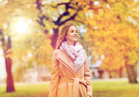 beautiful happy young woman walking in autumn parkの写真素材