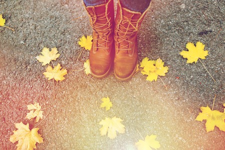female feet in boots and autumn leavesの写真素材
