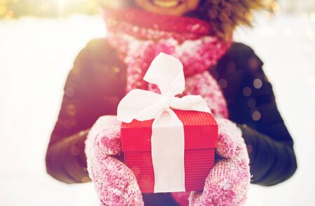 close up of woman with christmas gift outdoorsの写真素材
