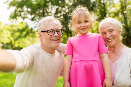senior grandparents and granddaughter selfieの写真素材
