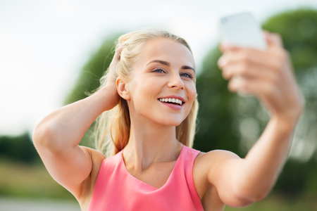 happy woman taking selfie with smartphone outdoorsの写真素材