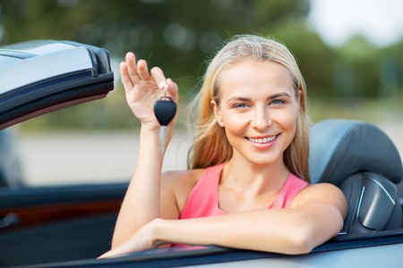 happy young woman with convertible car keyの写真素材