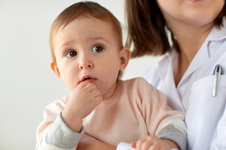doctor or pediatrician with baby on medical examの写真素材