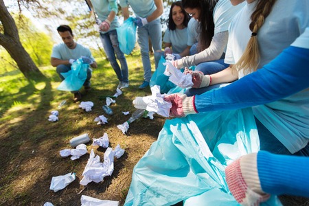 volunteers with garbage bags cleaning park areaの写真素材