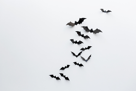 halloween and decoration concept - black paper bats flying over white backgroundの写真素材