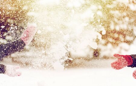 people, season, winter holidays and christmas concept - happy friends playing with snow outdoorsの写真素材