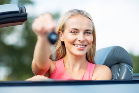 happy young woman with convertible car keyの写真素材