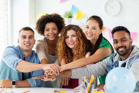 happy team at office party holding hands together