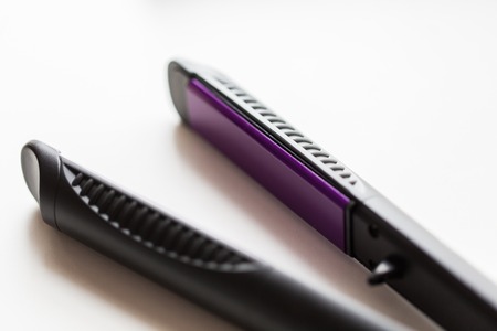 hair tools, beauty and hairdressing concept - close up of flat straightening iron on white backgroundの写真素材