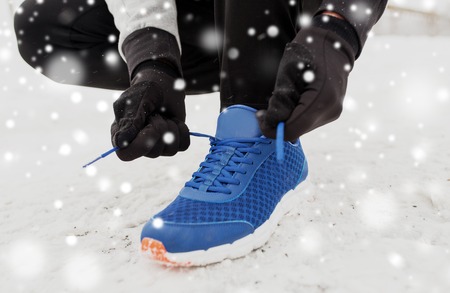 close up of man tying shoe lace in winter outdoorsの写真素材