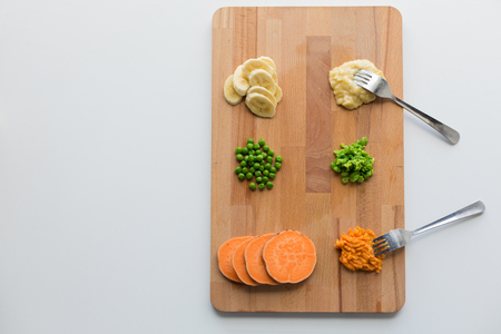 mashed fruits and vegetables with forks on boardの写真素材