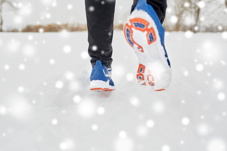 close up of feet running along snowy winter roadの写真素材