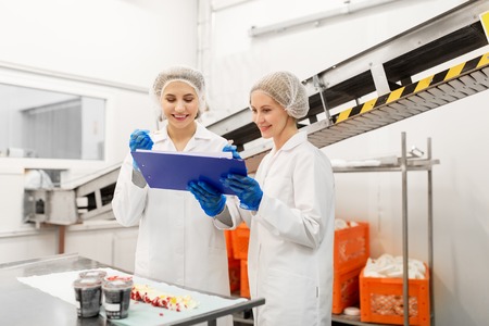 women technologists tasting ice cream at factoryの写真素材