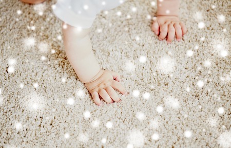 hands of baby crawling on floor or carpetの写真素材