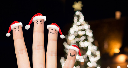 close up of fingers in santa hats at christmas