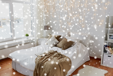 bedroom with bed and christmas garland at homeの写真素材