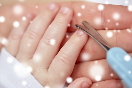 close up of hand with scissors trimming baby nailsの写真素材