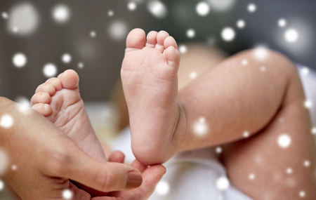 close up of newborn baby feet in mother handsの写真素材