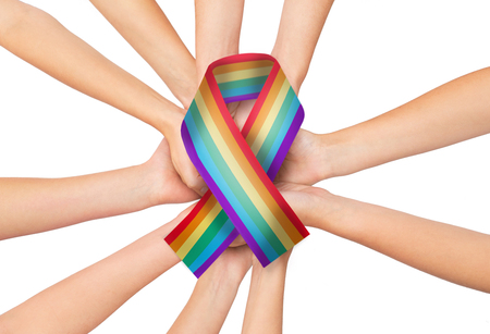 female hands holding gay pride awareness ribbonの写真素材