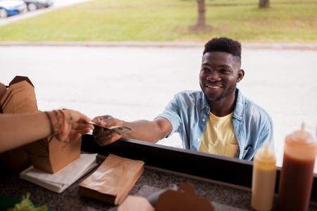 african american man buying wok at food truckの写真素材
