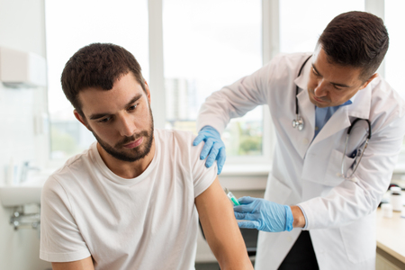 patient and doctor with syringe doing injectionの写真素材