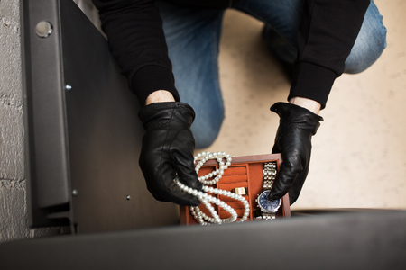thief stealing valuables from safe at crime sceneの写真素材