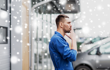 auto mechanic smoking cigarette at car workshopの写真素材