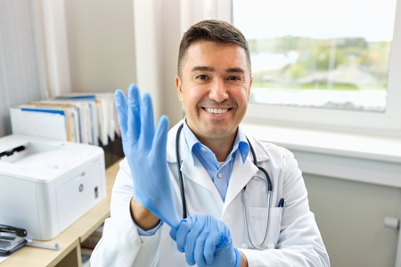 smiling doctor with protective gloves at clinicの写真素材