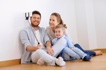 family taking selfie by smartphone at new homeの写真素材