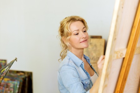 woman with easel drawing at art school studioの写真素材
