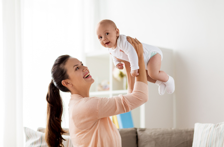 happy mother playing with little baby boy at homeの写真素材