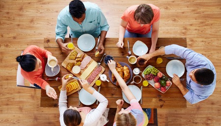 group of people having breakfast at tableの写真素材
